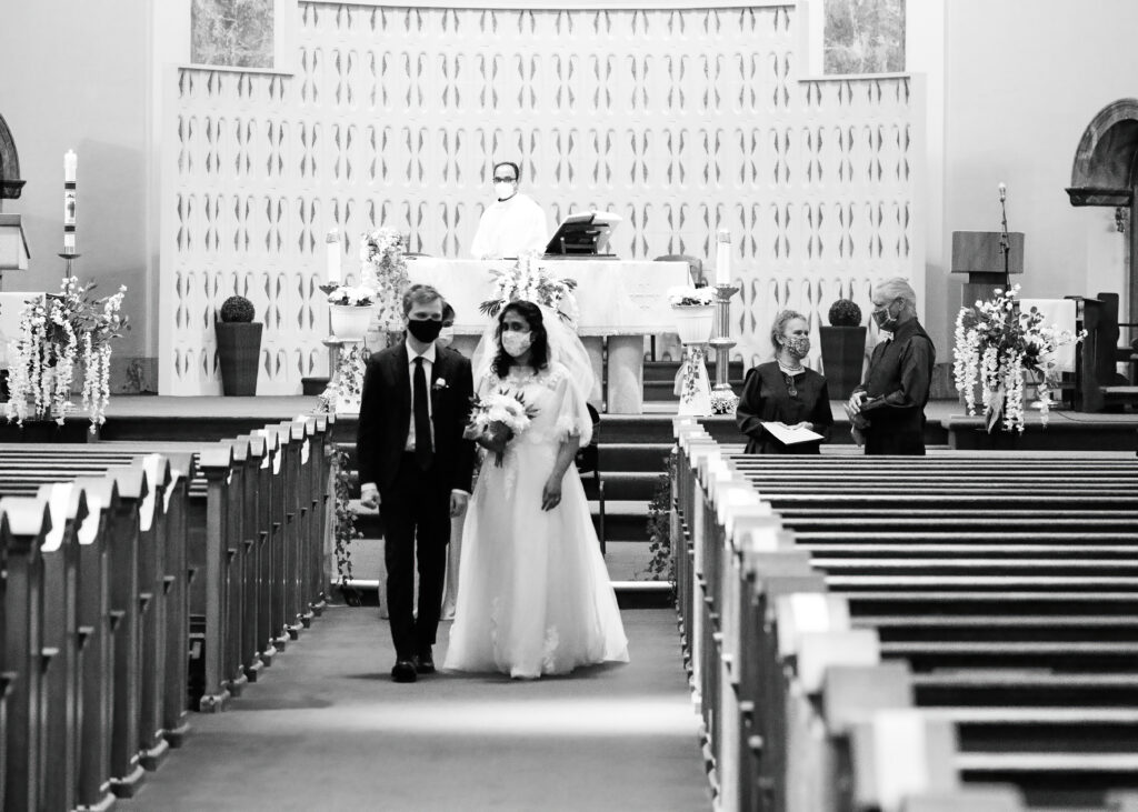 My Wedding Photos. Bride and Groom leaves the Church. Priest looks on.