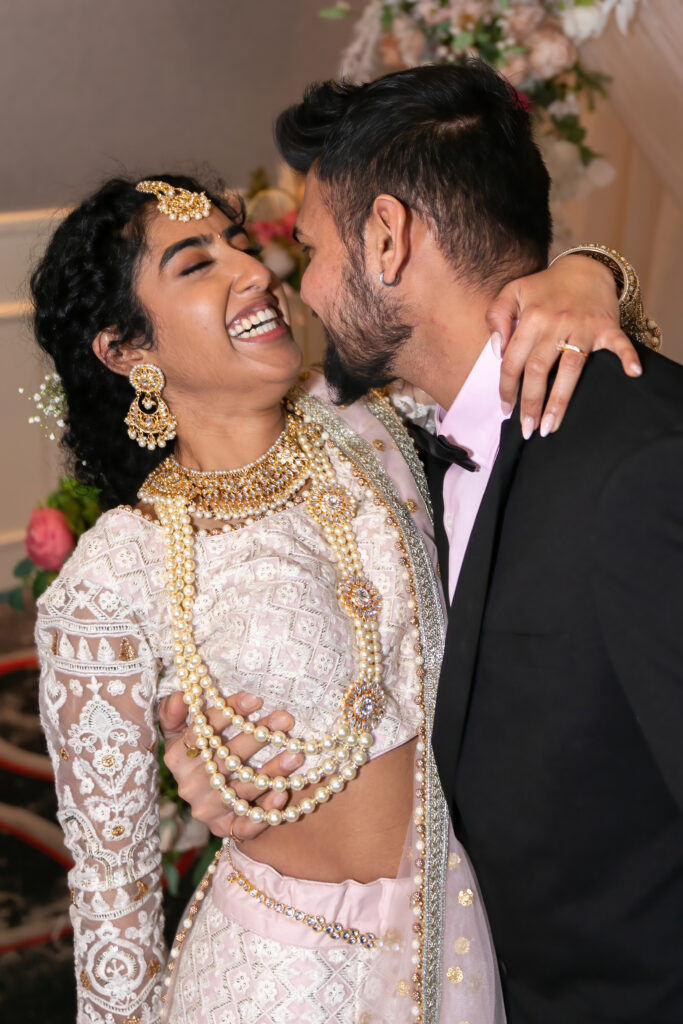 Wedding photography Indian. Bride and Groom embrace and laugh.